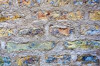 Distressed brick wall with rough mortar, creating a rugged abstract background texture [IBR125424555]