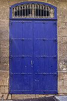 An old wooden blue door in a Mediterranean setting in a historic town in Italien [IBR125436226]