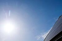 Solar panels on a roof generating clean energy under a bright blue sky [IBR125436238]