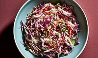 Fresh coleslaw in blue bowl. Red cabbage, carrots, green herbs. Bright colors, appetizing dish. Top-down view, rustic background, AI generated [IBR125446415]