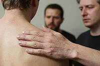 Emotional support and male vulnerability through a gentle hand on a bare shoulder, conveying empathy, brotherhood, grief processing, mental health, interpersonal tactile communication establishes psychological comfort between distressed individuals, the e [IBR125446424]