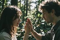 Intimate touch between two lovers in lush woods, tender fingertip contact unites masculine and feminine energy amid natural sun rays, silent communication through palm alignment creates deep interpersonal resonance, reciprocal empathy reflected in soft ga [IBR125446427]