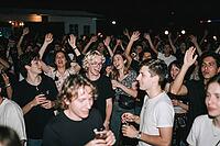 Ecstatic youth subculture embracing nocturnal open air concert freedom, joyful friends raising hands in celebration, nocturnal festival escapism, laughing partygoers holding drinks while swaying to rhythmic acoustic vibrations, emotional social bonding un [IBR125446433]
