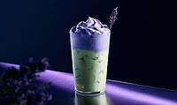 Purple-hued iced drink with whipped cream and lavender garnish. Glass sits on purple-lit surface, AI generated [IBR125446459]