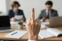 Corporate frustration and quiet quitting in modern office environment, an employee displays an offensive gesture during an executive meeting, open rebellion against administrative authority and toxic hierarchy, sharp foreground focus on defiant hand gestu [IBR125446461]
