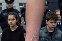 Adolescent vulnerability confronts institutional state power during juvenile policing, somber young individuals stand under the watchful gaze of uniformed police officers while a dominant human forearm splits the visual composition, raw skin textures and  [IBR125446509]
