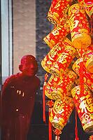 Chinese red decorative lanterns hang next to a red figure, evoking a festive mood during the celebration of Lunar New Year in Hong Kong [IBR125448814]