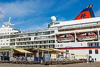 Seaside Toldboden restaurant with outdoor seating in front of cruise ship in port, summer, blue sky, Copenhagen, Denmark [IBR125448822]
