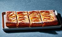 Freshly baked apple tart squares on metal tray. Golden crust with sliced apples. Dark blue background. Perfect for dessert or baking themes, AI generated [IBR125448881]
