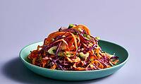 Fresh, colorful coleslaw served in shallow teal dish against soft purple background, AI generated [IBR125448885]