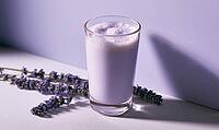 Lavender-flavored milk drink in clear glass beside dried lavender stems, AI generated [IBR125448890]