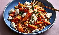 Blue plate holds roasted carrot sticks, bulgur, and crumbled feta. Fresh herbs garnish the dish. Gold fork rests beside food, AI generated [IBR125448892]
