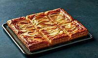 Golden-brown apple tart on dark tray. Crispy pastry with sliced apples. Perfect for dessert or breakfast. Rich, warm tones against dark background, AI generated [IBR125448907]