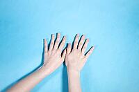 Overlook of two hands with fingers on blue paper background [IBR125462036]