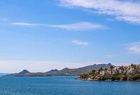 Bitez coastal landscape with traditional white architecture on green hills overlooking the tranquil blue waters of the Aegean Sea [IBR125462064]