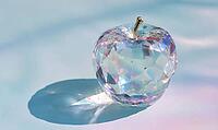 A shiny, colorful apple sits on a table. The apple is surrounded by a blue background, and the light shining on it creates a beautiful, AI generated [IBR125472309]