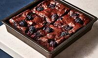 Freshly baked chocolate brownies topped with blackberries in a baking tray, AI generated [IBR125472323]