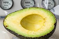 Fresh halved avocado sealed in vacuum packaging undergoes high pressure processing pascalization technology, preventing enzymatic browning naturally, industrial food engineering relies on cold hydrostatic pasteurization at extreme mega pascal forces, pres [IBR125472332]