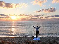 A woman does yoga at sunrise on Tortoli beach, Sardinia, 29.09.2026, Tortoli, Italy [IBR113453104]