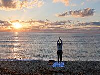A woman does yoga at sunrise on Tortoli beach, Sardinia, 29.09.2026, Tortoli, Italy [IBR113453107]