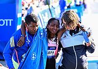 27 September 2026, Athletics: BMW Berlin Marathon 2026, from left: Tigst Assefa (ETH 2:11:04) crosses the finish line, exhausted, and is supported by a team at the 2026 BMW BERLIN MARATHON [IBR113453163]