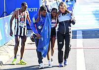27 September 2026, Athletics: BMW Berlin Marathon 2026, from left: Tigst Assefa (ETH 2:11:04) crosses the finish line, exhausted, and is supported by a team at the 2026 BMW BERLIN MARATHON [IBR113453171]