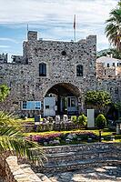 Marmaris, Turkey, 19.06.2026. Historical medieval fortress building featuring a stone arch entrance gate with ancient ruins and a blooming garden on a sunny summer morning in Marmaris resort [IBR125492357]