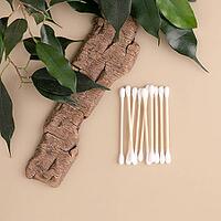 Eco-friendly wooden cotton swabs on tree bark and green leaves promote a sustainable approach to beauty and self-care. Green lifestyle, environmental awareness, consumption [IBR125492363]