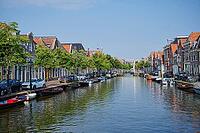 Alkmaar, Netherlands - 12th century August 2020: Boats moored in a wide canal in the middle of the residential area of Alkmaar, Netherlands [IBR125492420]