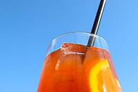 Refreshing orange summer cocktails with ice against a blue sky background [IBR125501596]