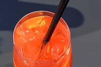 Refreshing orange summer cocktails with ice against a blue sky background [IBR125501606]