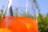 Refreshing orange summer cocktails with ice against a blue sky background [IBR125501620]