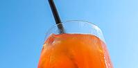 Refreshing orange summer cocktails with ice against a blue sky background [IBR125501622]