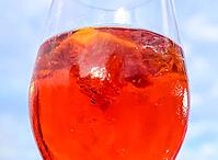 Refreshing orange summer cocktails with cola and ice against a blue sky background. Close up view [IBR125501635]