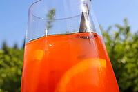 Refreshing orange summer cocktails with ice against a blue sky background [IBR125501636]