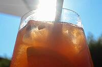 Refreshing orange summer cocktails with ice against a blue sky background [IBR125501644]