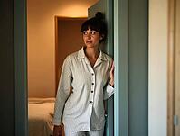 Young woman in pajamas looking away thoughtfully while exiting her bedroom after waking up in the morning, AI generated [IBR125502132]