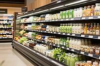 Refrigerated supermarket shelves display organic bottled dairy products, green smoothies, fresh fruit juices, retail cold chain storage logistics, commercial multi deck refrigeration equipment illuminates pasteurized whole milk, probiotic drinkable yogurt [IBR125502134]