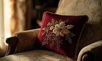 Deep red pillow with gold poinsettia embroidery, paired with dark green accents, set on a beige armchair, AI generated [IBR125502152]
