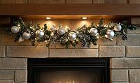 Cozy fireplace mantle with minimal holiday decor, featuring a white garland with silver ornaments and a few pine cones, AI generated [IBR125502181]