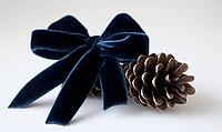 Two small pinecones tied with a dark blue velvet ribbon, set on a white background, AI generated [IBR125502213]