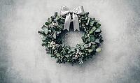 Christmas wreath made of eucalyptus and white holly berries, with a thin silver ribbon bow at the top, AI generated [IBR125502216]