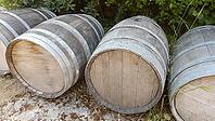 Several large wine barrels lie on a gravelly ground in the countryside, Patras, Greece [IBR125521083]