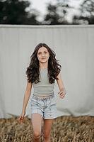 Brown-haired girl, 11, in a cornfield against a beige background [IBR125521109]