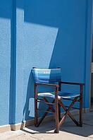 Wooden folding chair standing on blue house wall, Punta Marina, Ravenna, Emilia-Romagna, Italy [IBR125521117]