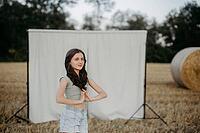 Brown-haired girl, 11, in a cornfield against a beige background [IBR125521138]