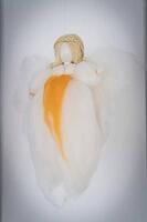 A simple angel made of white cotton wool with orange accent and braided hair, Baden-Württemberg, Germany [IBR125521178]