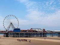 Blackpool, Lancashire, United Kingdom - 26 June 2024 : the famous blackpool donkey ride on the beach in front of the central pier [IBR125527051]