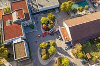 Aerial view of a paved square with fire engines between modern buildings and small groups of trees, Nagold, Calw district, Germany [IBR125527053]