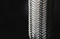 Exhaust Flexible Joint For Car System. Automotive Stainless Steel Muffler Connection. The new metal part is welded to the pipe. repair. Close-up. Black and white [IBR125527055]